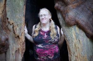 Dana Morrigan standing inside a hollow redwood tree.